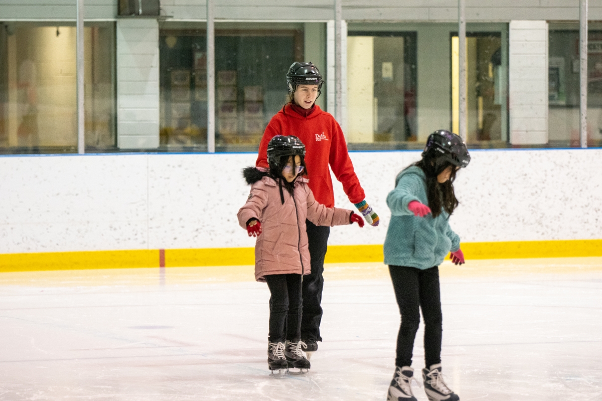 Skating students stay close to the instructor as they learn to skate.