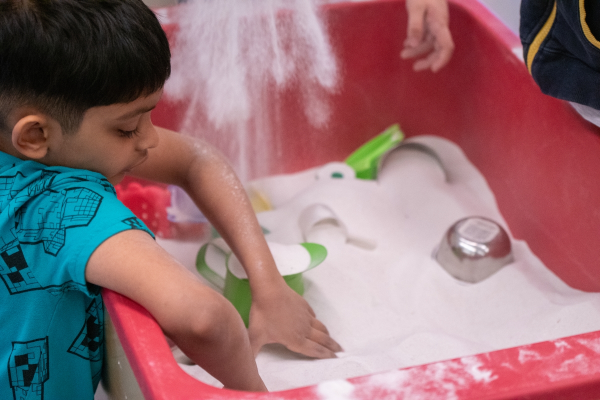 A student plays by themselves at a community recreation program. 