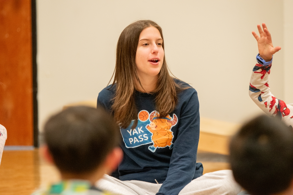 A community recreation leader leads a class of children. 