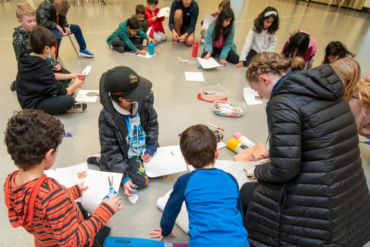 Campers make crafts in a circle at day camp. 